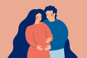 Young man embraces his smiling pregnant woman. The husband supports his wife expecting a baby. Family concept.